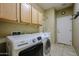 Laundry room with tile flooring, cabinets, and laundry sink at 16528 W Lariat Ln, Surprise, AZ 85387