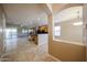 Open floor plan showcasing kitchen and living area with tiled flooring and ample natural light at 16528 W Lariat Ln, Surprise, AZ 85387