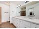 Well-lit bathroom featuring double sinks and a large vanity with white cabinetry at 17830 N 45Th Ave, Glendale, AZ 85308