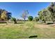 Well-maintained community entrance with lush green space and mature trees under a clear blue sky at 17830 N 45Th Ave, Glendale, AZ 85308