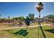 Fenced community playground with a shade tree, play equipment, and sidewalks for easy access at 17830 N 45Th Ave, Glendale, AZ 85308