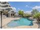 Inviting backyard with a sparkling pool, covered patio, and outdoor kitchen, ideal for entertaining at 18066 N Stonegate Rd, Maricopa, AZ 85138