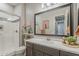 Bathroom features a walk-in shower, vanity with a framed mirror, decorative accents, and neutral tones at 18066 N Stonegate Rd, Maricopa, AZ 85138