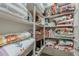 Organized linen closet featuring shelves filled with folded quilts, linens, and various storage containers at 18066 N Stonegate Rd, Maricopa, AZ 85138