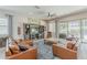 Spacious living room featuring a sectional sofa, ceiling fan, and sliding glass doors at 18066 N Stonegate Rd, Maricopa, AZ 85138