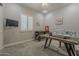 Bright, carpeted office space featuring a work table, sewing machine, and a window with plantation shutters at 18066 N Stonegate Rd, Maricopa, AZ 85138