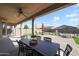 Covered patio with outdoor dining area overlooking a landscaped backyard at 18137 W Deer Creek Rd, Goodyear, AZ 85338