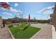Beautiful backyard featuring artificial turf, brick pavers, and decorative landscaping at 18137 W Deer Creek Rd, Goodyear, AZ 85338
