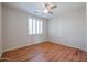 Clean bedroom boasts a fan, modern shuttered window, and wood-look flooring at 18137 W Deer Creek Rd, Goodyear, AZ 85338