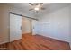 Large bedroom with wood flooring has a ceiling fan and sliding barn-style doors to closet at 18137 W Deer Creek Rd, Goodyear, AZ 85338