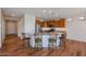 Bright kitchen featuring an island with bar stool seating, stainless steel appliances, and hardwood floors at 18137 W Deer Creek Rd, Goodyear, AZ 85338