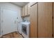 Well-equipped laundry room with front-load washer, dryer, and storage cabinets at 18137 W Deer Creek Rd, Goodyear, AZ 85338
