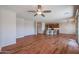 Spacious open concept living room and kitchen area featuring wood flooring and a ceiling fan for comfortable living at 18137 W Deer Creek Rd, Goodyear, AZ 85338