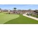 Putting green with a bench, trees, and desert landscaping at 18137 W Deer Creek Rd, Goodyear, AZ 85338