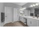 Bathroom featuring dual vanities, sleek lighting fixtures, and wood-look flooring at 18362 W Illini St, Goodyear, AZ 85338