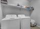 Functional laundry room with a washer, dryer and shelving for storing laundry essentials at 18362 W Illini St, Goodyear, AZ 85338