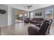 Spacious living room with tile flooring, a ceiling fan, and sliding glass doors to the backyard at 18362 W Illini St, Goodyear, AZ 85338