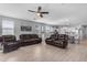 Open concept living room featuring tile floors, leather furniture, and abundant natural light from the windows at 18362 W Illini St, Goodyear, AZ 85338