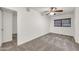 This carpeted bedroom is brightly lit from a window and the ceiling fan overhead at 1903 E Jasper Dr, Chandler, AZ 85225