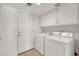 Well-lit laundry room features a washer, dryer, overhead storage and direct access to the exterior at 1903 E Jasper Dr, Chandler, AZ 85225