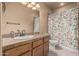 Well-maintained bathroom featuring a vanity with countertop and a shower with floral curtains at 20826 S Hadrian Way, Queen Creek, AZ 85142