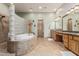 Luxurious bathroom with a soaking tub, tiled shower, and dual vanities at 20826 S Hadrian Way, Queen Creek, AZ 85142