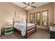 Traditional bedroom with a ceiling fan, three windows and a white comforter at 20826 S Hadrian Way, Queen Creek, AZ 85142