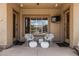 Inviting covered patio with comfortable seating, outdoor television, and easy access to the home's interior at 20826 S Hadrian Way, Queen Creek, AZ 85142