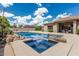 Resort-style backyard featuring a sparkling pool with integrated spa and decorative rock features under a blue sky at 20826 S Hadrian Way, Queen Creek, AZ 85142