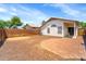 View of a spacious backyard with gravel and a brick patio, framed by a stucco home and privacy wall at 2221 E Union Hills Dr # 148, Phoenix, AZ 85024