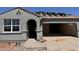 Gray stucco home with a tile roof being installed and an arched front entry at 22720 N Lynn St, Maricopa, AZ 85138