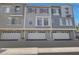 Three-story townhome featuring attached garages, stucco siding, and decorative shutters at 2402 E 5Th St # 1520, Tempe, AZ 85288