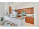 Galley kitchen featuring warm wood cabinets, stainless steel appliances, and a breakfast bar at 2402 E 5Th St # 1520, Tempe, AZ 85288