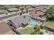 Aerial view of the property featuring a sparkling pool, covered patio, grassy area and block fence at 2435 E Harmony Ave, Mesa, AZ 85204