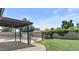 Inviting backyard featuring a refreshing pool, covered patio, and lush green lawn perfect for outdoor relaxation at 2435 E Harmony Ave, Mesa, AZ 85204