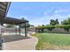 Private backyard featuring a pool, covered patio, grassy area and block fence at 2435 E Harmony Ave, Mesa, AZ 85204