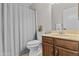 Bathroom featuring wood cabinets and a shower behind a stylish gray curtain at 2435 E Harmony Ave, Mesa, AZ 85204