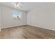 Bright bedroom features wood-look floors, a ceiling fan, and a window with blinds at 2435 E Harmony Ave, Mesa, AZ 85204