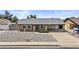 Charming brick home featuring a covered carport, low maintenance yard, and inviting curb appeal at 2435 E Harmony Ave, Mesa, AZ 85204
