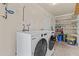 A well-equipped laundry room featuring modern, white appliances and plenty of storage at 2435 E Harmony Ave, Mesa, AZ 85204
