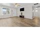 Open living room with wood-look flooring, a ceiling fan, and great natural light at 2435 E Harmony Ave, Mesa, AZ 85204