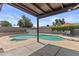 Backyard pool featuring a covered patio, diving board, and lounge chairs at 2435 E Harmony Ave, Mesa, AZ 85204