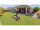 Lush backyard with a covered patio, well-maintained lawn, and desert landscaping at 26032 W Quail Ave, Buckeye, AZ 85396