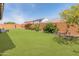Beautifully landscaped backyard with lush green lawn, vibrant flowers, and seating area at 26032 W Quail Ave, Buckeye, AZ 85396