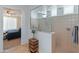 Bright bathroom with a glass enclosed shower and a view to the main bedroom at 26032 W Quail Ave, Buckeye, AZ 85396