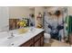 Bathroom with double sinks, a shower and tub combination, and wood-look accents at 26032 W Quail Ave, Buckeye, AZ 85396