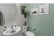 Stylishly decorated powder room featuring a round mirror and decorative plants at 26032 W Quail Ave, Buckeye, AZ 85396