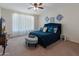 Comfortable bedroom features a large blue bed, ceiling fan, and stylish decor at 26032 W Quail Ave, Buckeye, AZ 85396