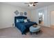 Comfortable bedroom features a large blue bed, ceiling fan, and stylish decor at 26032 W Quail Ave, Buckeye, AZ 85396
