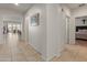 Bright hallway with neutral tile flooring, leading to bedrooms and living spaces at 26032 W Quail Ave, Buckeye, AZ 85396
